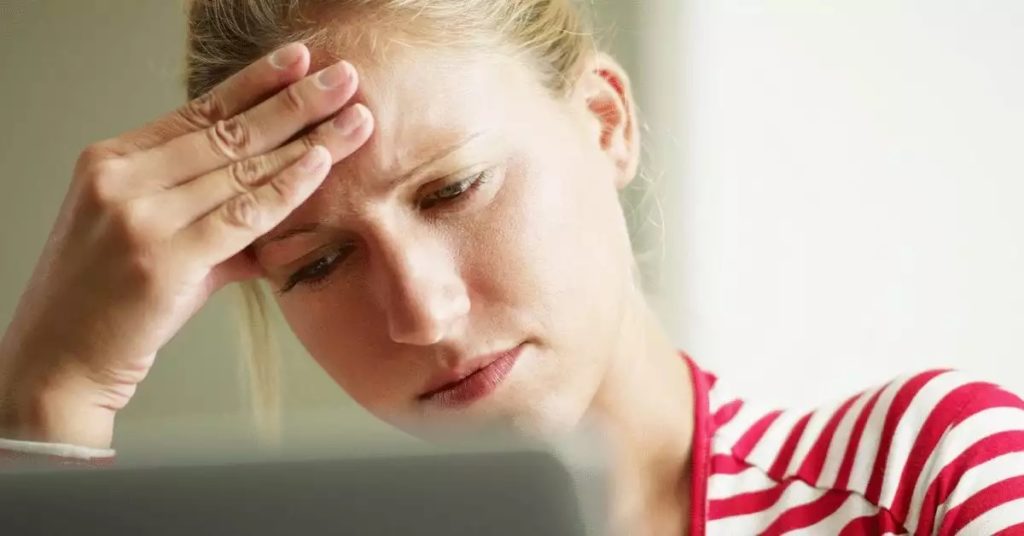 woman holding her head from concussion head injury