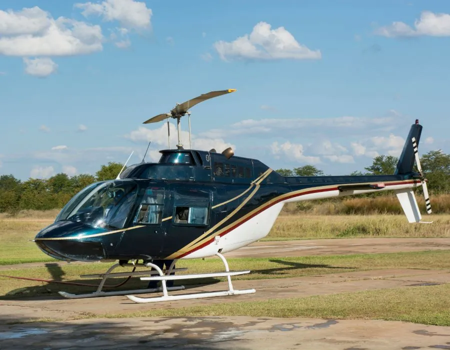 helicopter sitting in field getting ready to take off