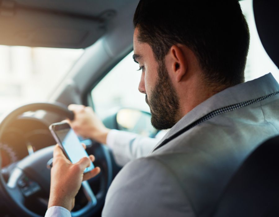 man looking at phone while driving